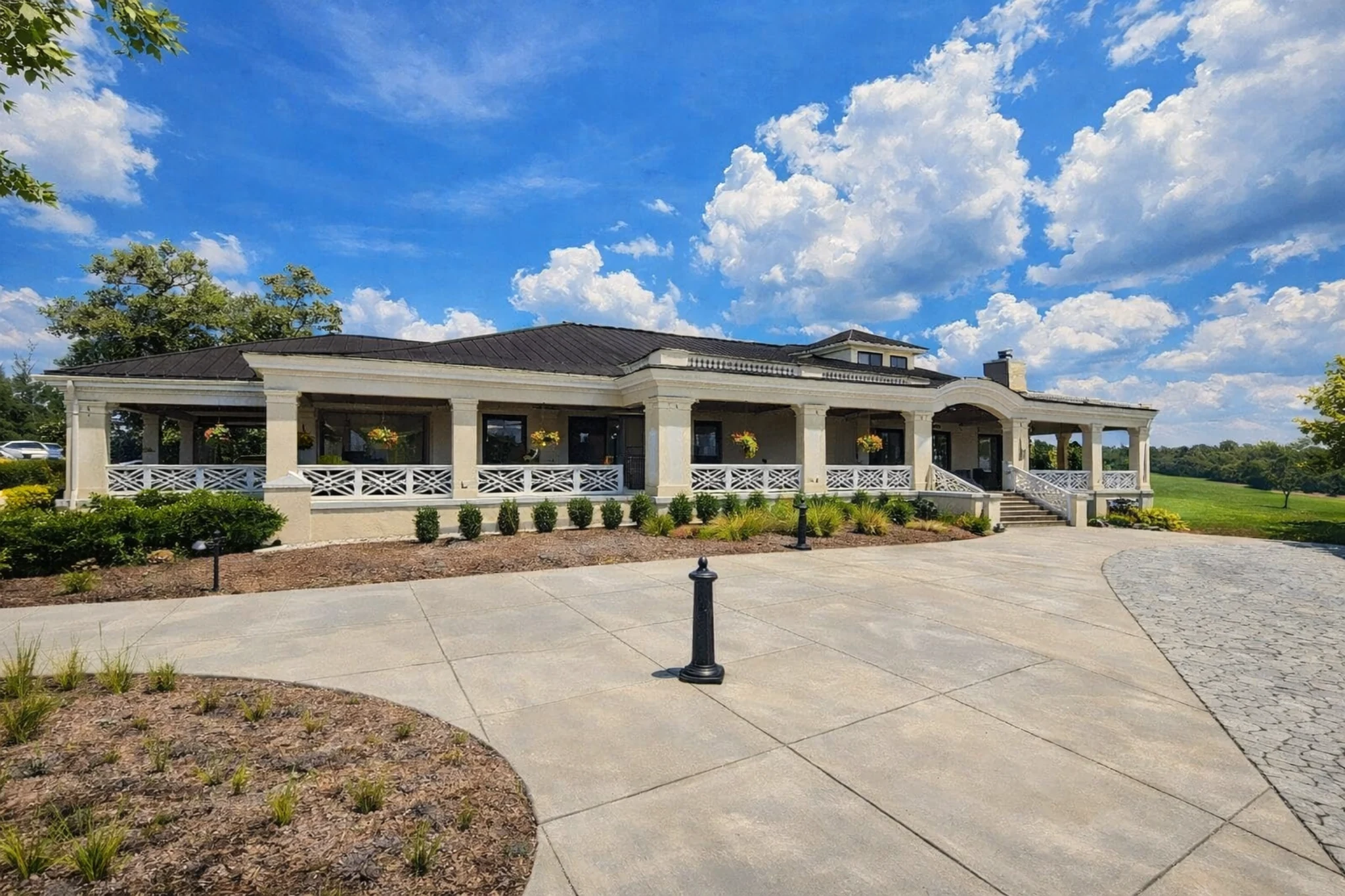 Veranda style building at Four Roses Distillery with white railings and landscaped entry.