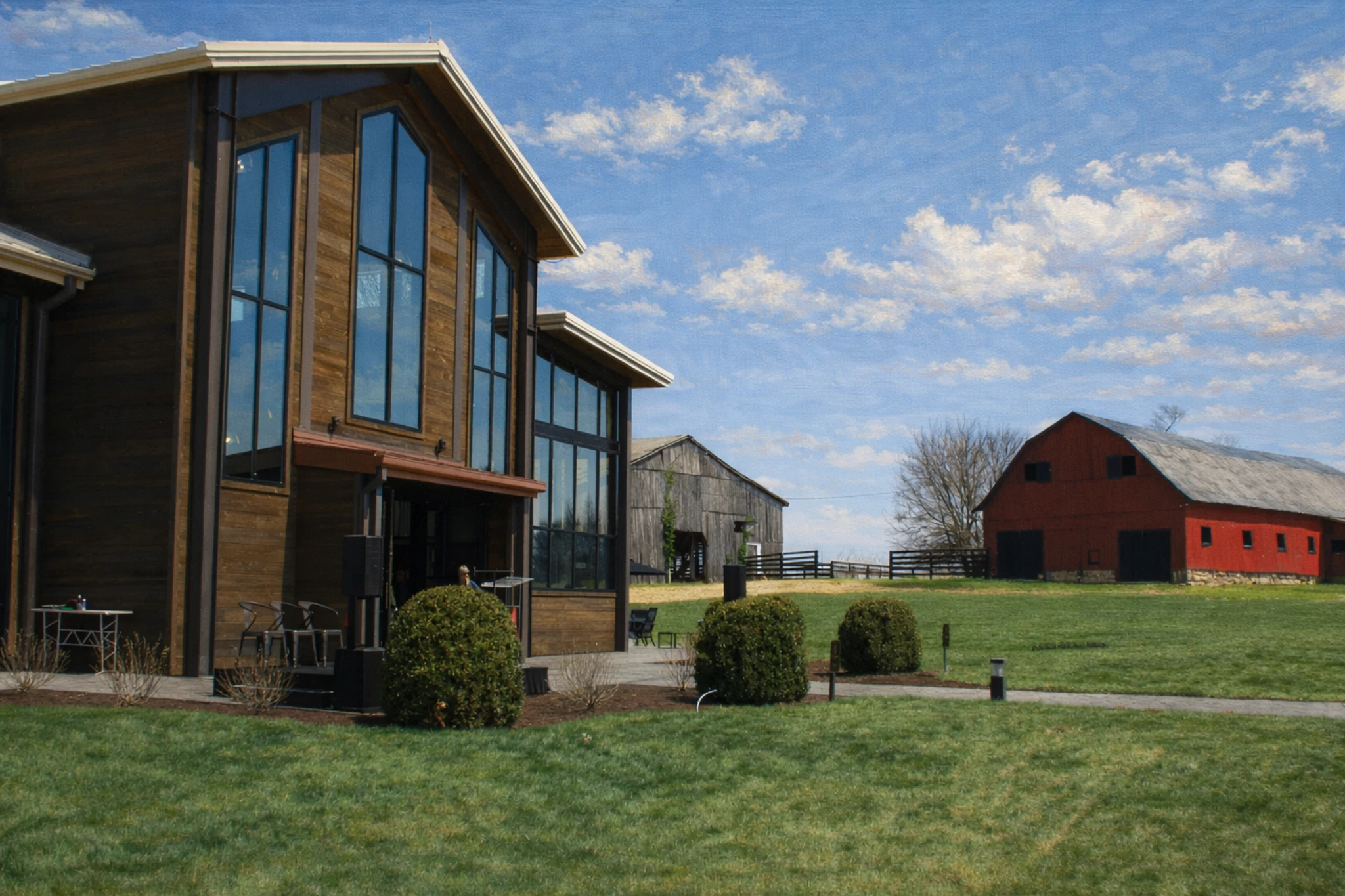 Exterior view of the Lux Row Distillers tasting room with modern wood architecture and historic red barn nearby.