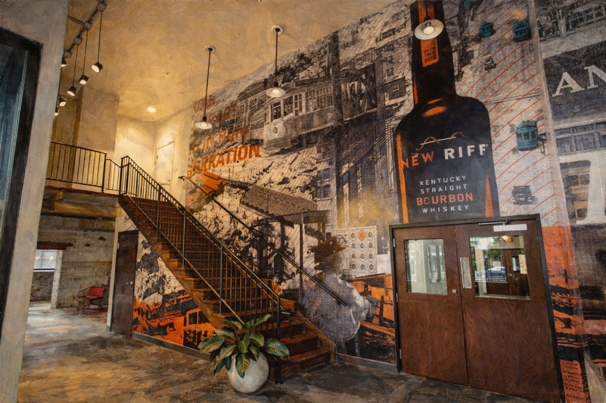 New Riff Distilling lobby with staircase and large wall mural featuring a New Riff Kentucky Straight Bourbon Whiskey bottle.