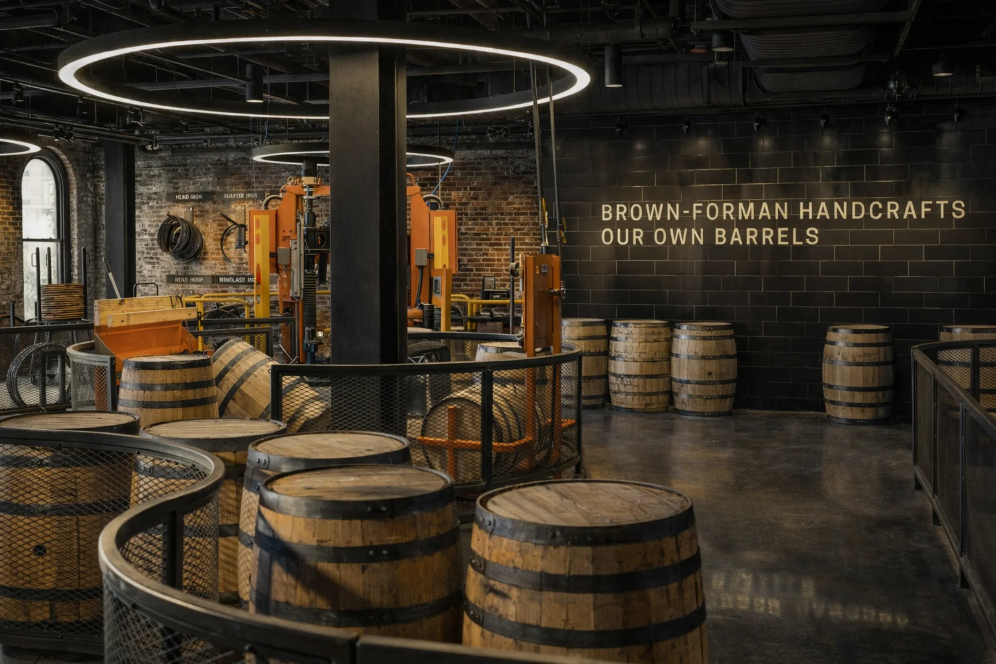Brown-Forman cooperage exhibit with barrel-making equipment, stacked barrels, and the text “BROWN-FORMAN HANDCRAFTS OUR OWN BARRELS.”