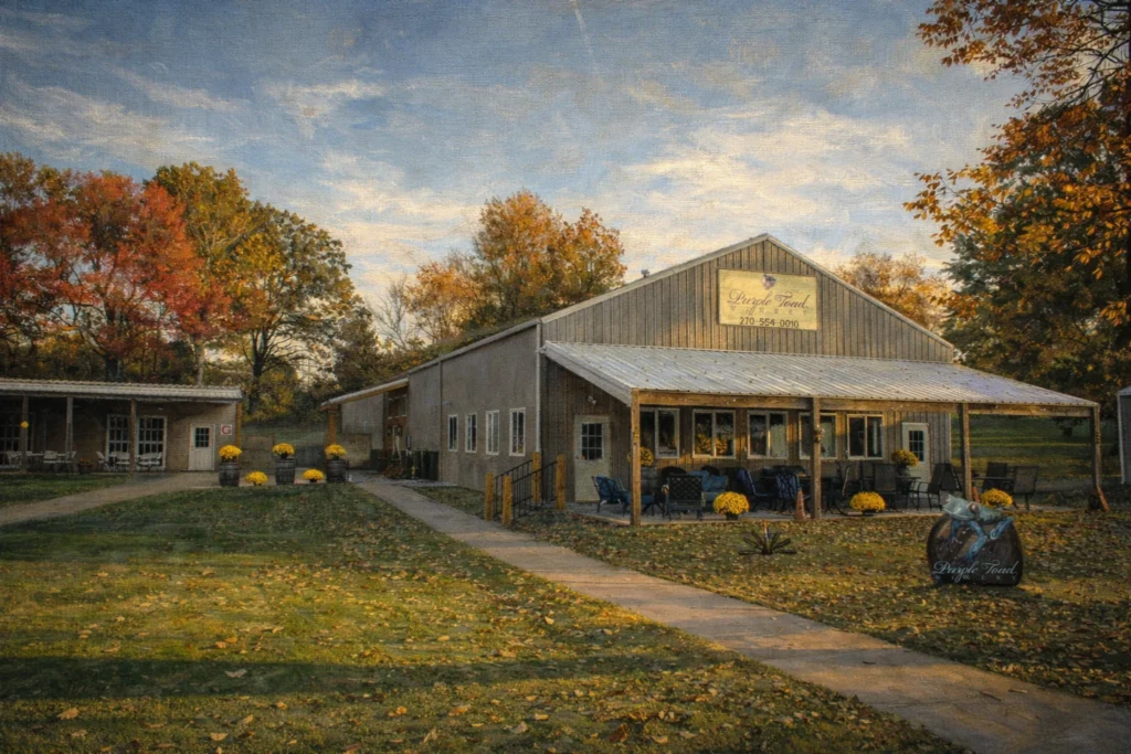Purple Toad Distillery exterior with a covered patio and seating, fall-colored trees, and a Purple Toad sign above the entrance.