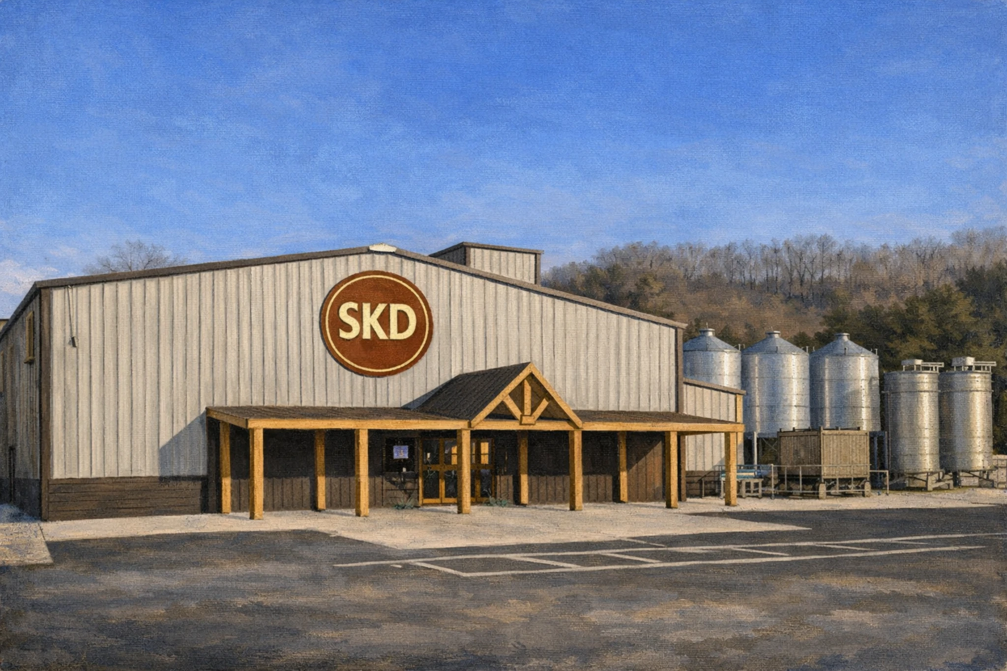 Front exterior of Southern Kentucky Distillery featuring a barn-style building with the SKD logo above the entrance and grain silos beside the structure.