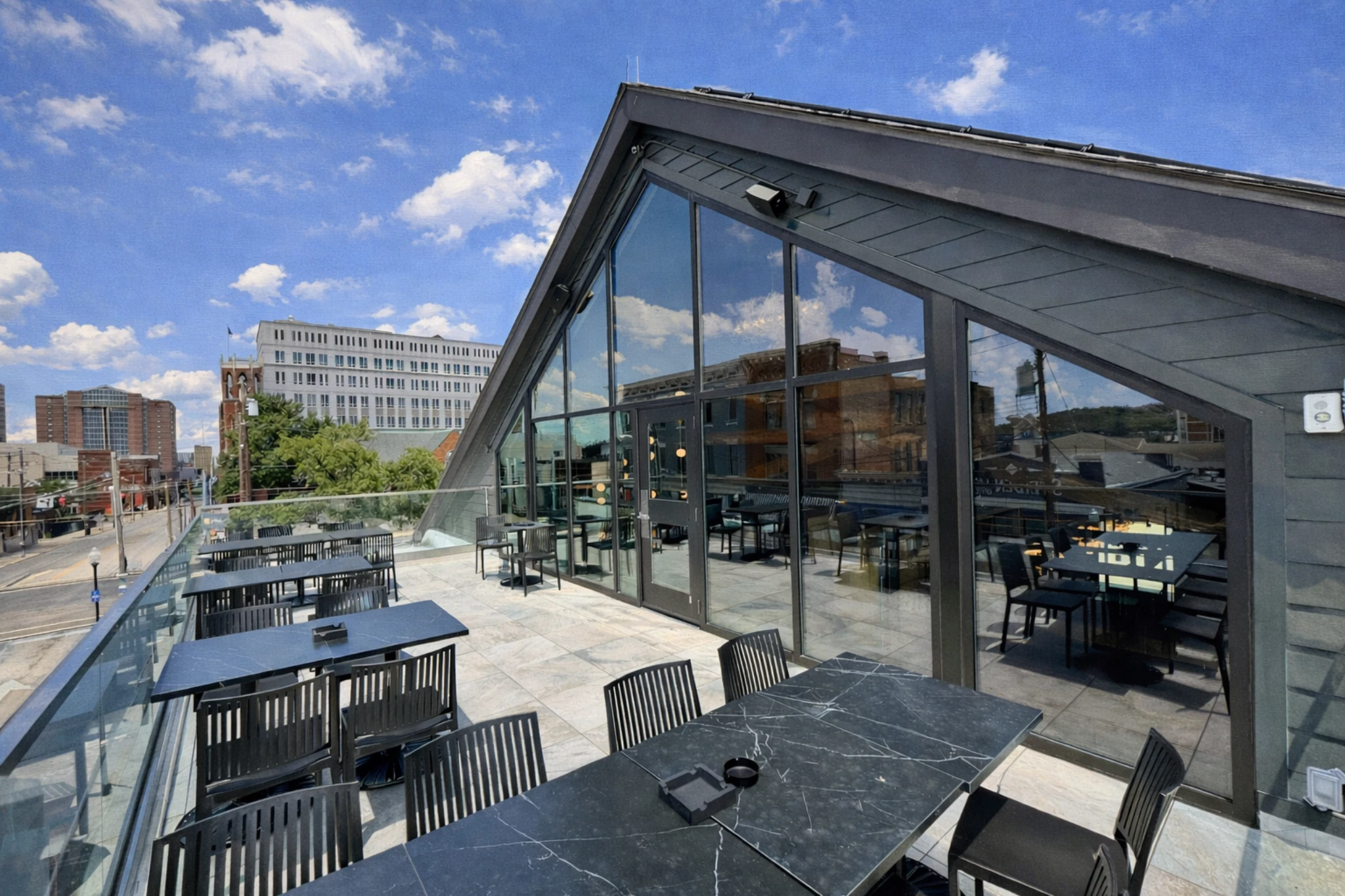 Rooftop patio at Wenzel Distillery with outdoor tables and seating overlooking the surrounding downtown area.