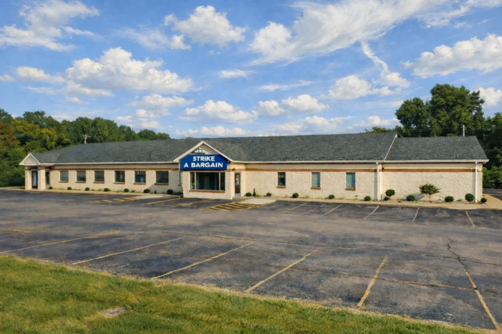 Strike a Bargain storefront and parking lot in Bardstown, Kentucky under a partly cloudy sky.